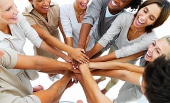 Multi-ethnic group of people linking hands