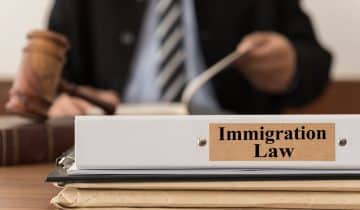 Man in suit with gavel and immigration law binder