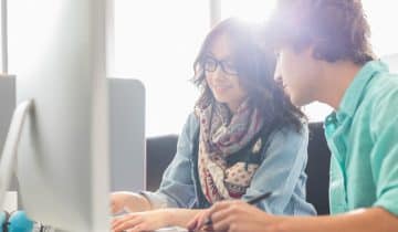 Male and female interns at computer