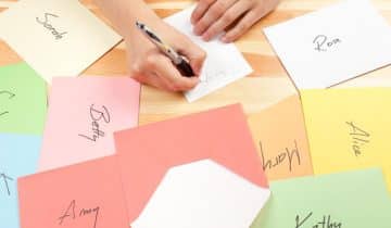 Close up of hand with pen addressing cards