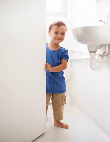 Smiling child looking out from the bathroom