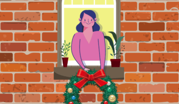 woman hanging wreath on house